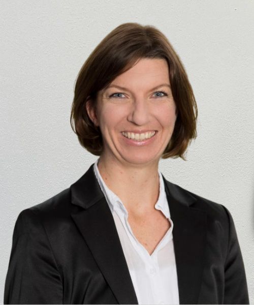 Sara_Kunkel_Web2025 Zwei grüne Sessel dazwischen ein Metallregal mit Zeitschriften